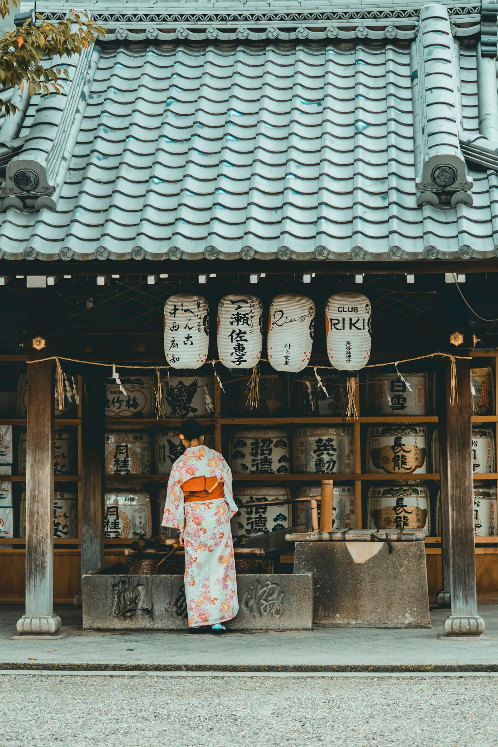 Femme en kimono devant une maison traditionnelle japonaise