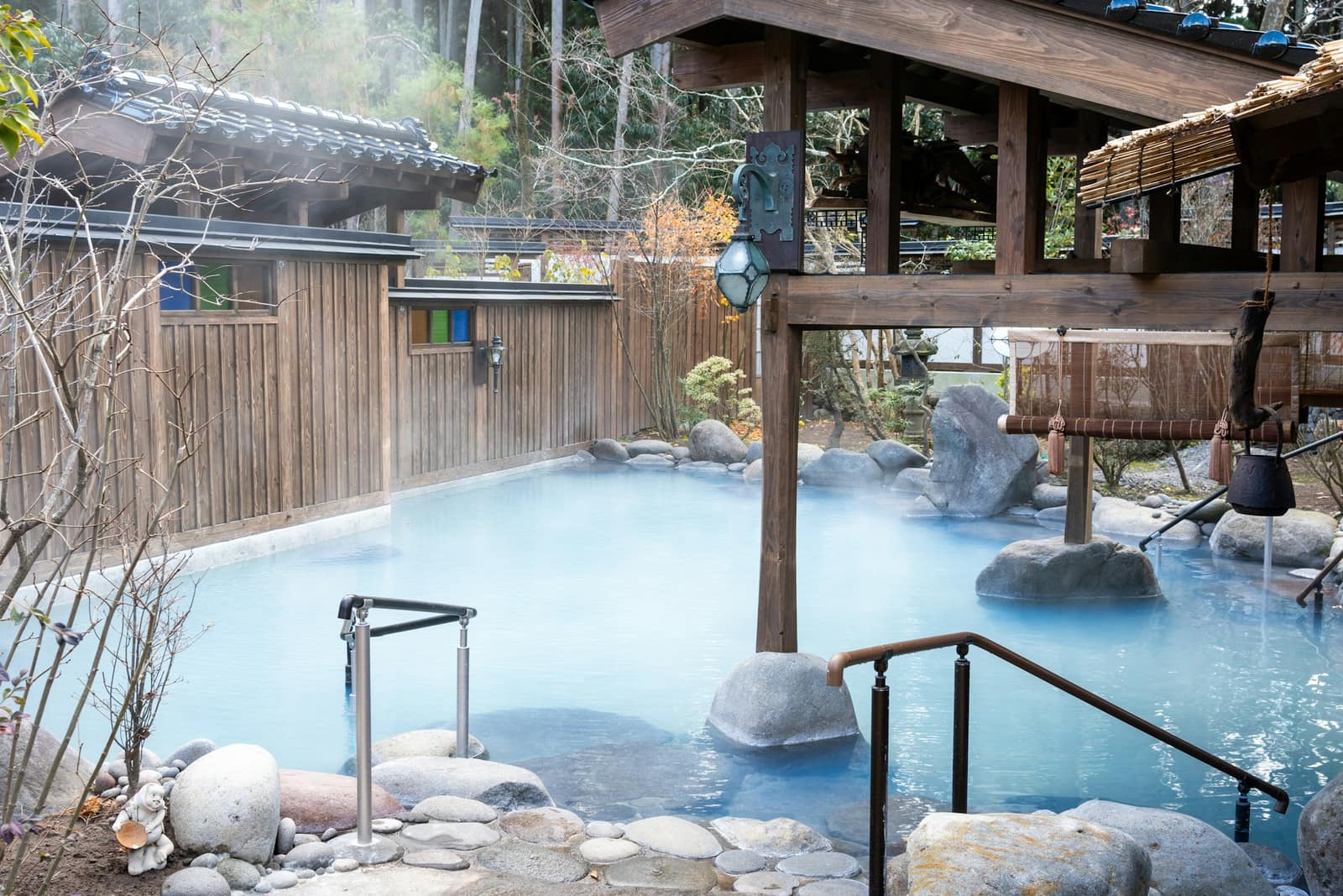 Bain d’onsen extérieur à l’eau laiteuse dans un jardin japonais