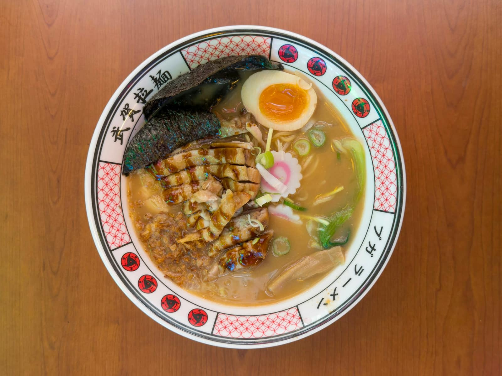 Bol de ramen vu de dessus, avec œuf mollet, chashu, pousses de bambou et naruto